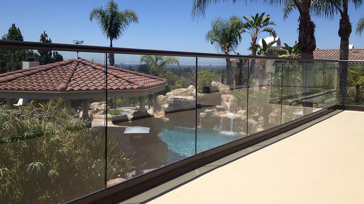 deck over looking pool with glass fence wall